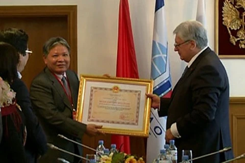 Minister of Justice Ha Hung Cuong (L) presents the order to the Russian institute (Photo: VNA)