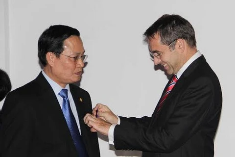 Prof. Nguyen Huu Duc (L) is presented with the Order of Academic Palms by French Ambassador Jean-Noel Poirier (Photo: VNA)