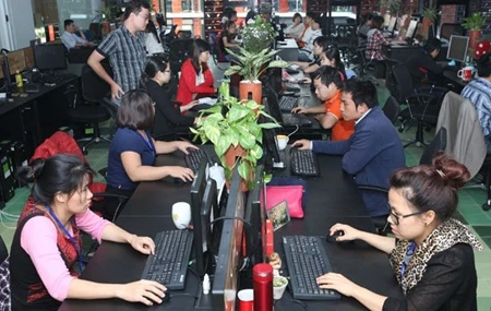 Information technology employees work at the FPT Software Co Ltd's F-Village software village in Hanoi (Photo: VNA)