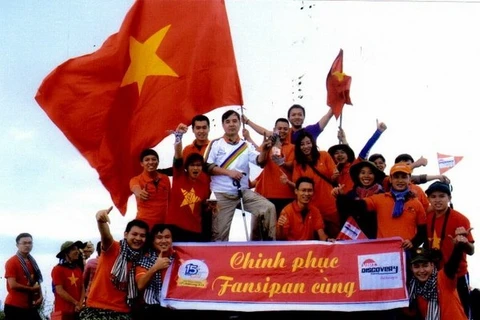 The largest group from FPT University singing national anthem at the Fansipan's summit. (Photo: VNA)