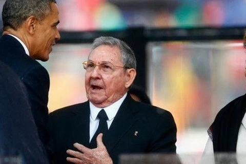 President Raul Castro (second, left) and his US counterpart Barack Obama (first, left) shake hands at the funeral of late South African President Nelson Mandela (Photo: Reuters)