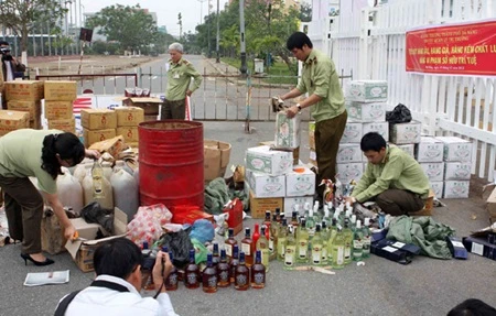 Staff from Da Nang's Market Watchdog Department destroy counterfeit goods (Photo: VNA)