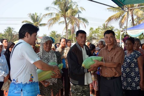 Nguyen Thanh Tung, Chairman of The Association of Cambodians of Vietnamese Origin in Koh Kong province (first, left) presents gifts to poor overseas Vietnamese (Photo: VNA)