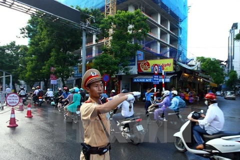 A traffic police officer performs his duty on a busy street in Hanoi (Photo: VNA)