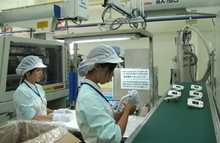 Employees work on blood pressure meters on a production line at the foreign-invested Key Plastics Co,Ltd. in the southern province of Binh Duong (Photo: VNA)
