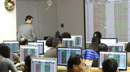 Investors watch stocks trading on Hoang Gia Securities Co's trading floor in Ha Noi. The VN-Index closed higher yesterday thanks to gains made by bank and property shares (Photo: VNS/VNA)