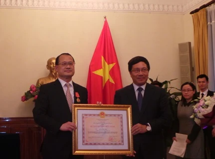 Dr Jonathan Choi (left) receives the Friendship Order from Deputy PM Pham Binh Minh (Photo: VNA)