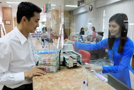 A customer conducts a transaction at a branch of Vietinbank in HCM City. Bank savings remain a good choice due to low inflation. (Photo: VNA)