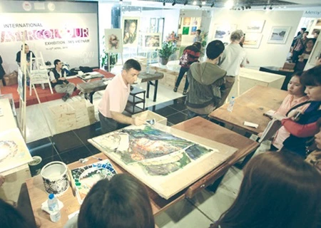 A Canadian artist paints at the first large-scale watercolour exhibition in Ha Noi. (Photo: VNA)