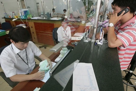 Transactions at a Vietcombank branch in Ha Noi. The bank is seeking a merger partner to boost its scale, capital and network. (Photo: VNS)