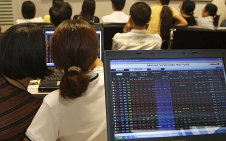 Investors watch market movements at a securities trading floor in Ha Noi. (Photo: VNA)