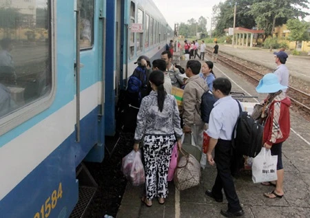 Passengers get on a train (Photo: VNA)