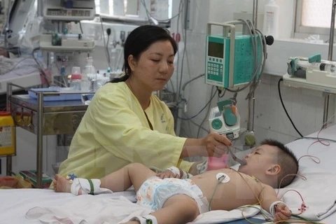 A nurse is taking care of a child contracted hand-foot-mouth disease (Photo: VNA)