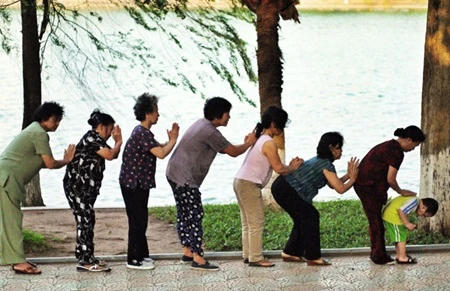Senior citizens do morning exercises at the Hoan Kiem (Sword) Lake in Hanoi (Photo: VNA)