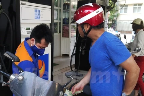 A motorcyclist has his vehicle's gas tank filled (Photo: VNA)