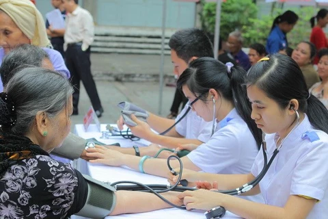 Medical workers give free check-ups to the elderly (Illustrative photo: VNA)