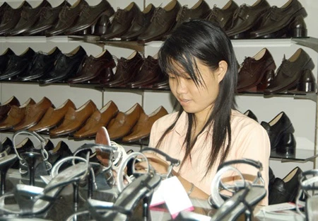A customer examines leather shoes made by the Vina Shoes Corporation at a store in HCM City. Vietnam has become the largest footwear exporter to Brazil with a turnover of 335.66 million USD last year. (Photo: VNA)