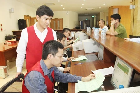 Ha Noi Stock Exchange staff check results of a share auction. (Photo: VNA)