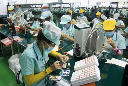 Staff at Foster Electronics Company in Quang Ngai province work on a headphone production line (Photo: VNA)
