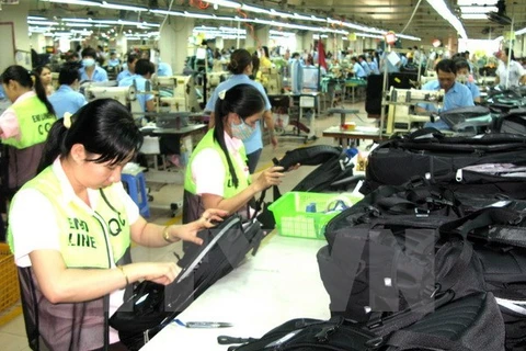 Workers make backpacks at a factory (Photo: VNA)