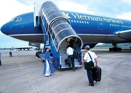 Passengers board a Vietnam Airlines plane. The carrier is speeding up divestment of non-core businesses. Photo: vietnamdomesticflights.com