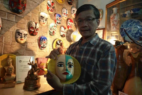 Hombre con pasión por máscaras del arte tradicional de Vietnam 