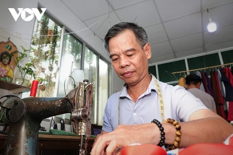 Un sastre apasionado por promover la túnica tradicional “ngu than” entre jóvenes