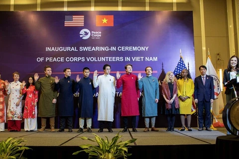 Maestros voluntarios estadounidenses vestidos con Ao Dai vietnamita en ceremonia de juramento