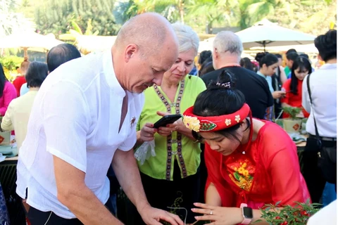 Visitantes extranjeros disfrutan del Festival de preparación de Banh Chung en Binh Thuan