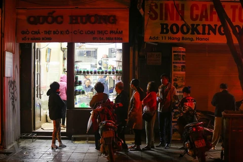  Habitantes de Hanoi hacen cola para comprar Banh Chung en tiendas famosas el último día del año lunar