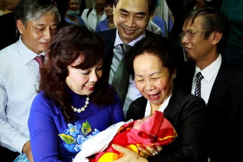 La vicepresidenta Nguyen Thi Doan y la ministra de Salud Nguyen Thi Kim Tien con la habitante 90 millones de Vietnam (Fuente: VNA)