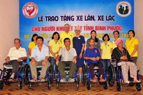 Binh Phuoc: une organisation américaine offre des fauteuils roulants à des handicapés