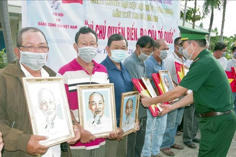 Remise des drapeaux nationaux et des portraits de l'Oncle Ho aux pêcheurs des zones côtières