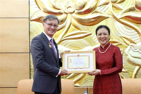 Insigne "Pour la paix et l'amitié entre les nations" à l'ambassadeur du Laos au Vietnam