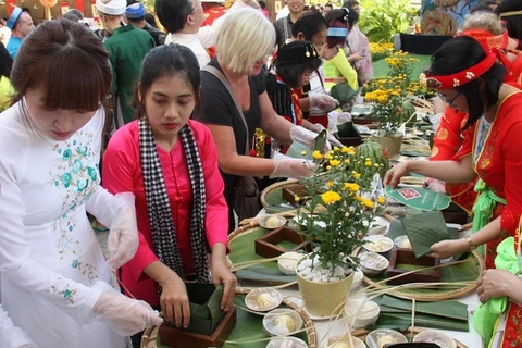Des touristes étrangers font l’expérience du Têt vietnamien avec le festival du " Banh Chung "
