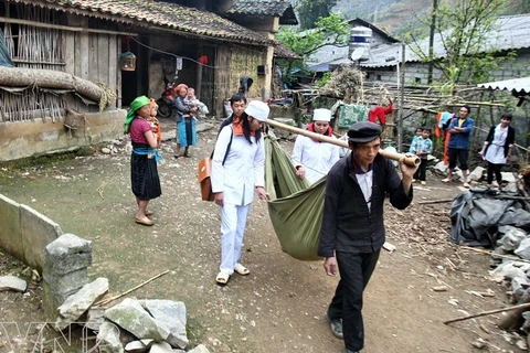 Transport d’un patient sur un brancard dans la commune de Lung Tao, district de Dông Van, province de Hà Giang. (Source: VNA)