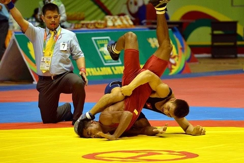 Le lutteur vietnamien Tran Van Tuong et son adversaire indonésien Rus Tang. (Photo: Thanh Ha-VNA)