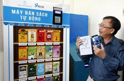 Le directeur de la compagnie des livres électroniques Tre (Ybook), Dông Phuoc Vinh, à côté d'un distributeur automatique de livres. 