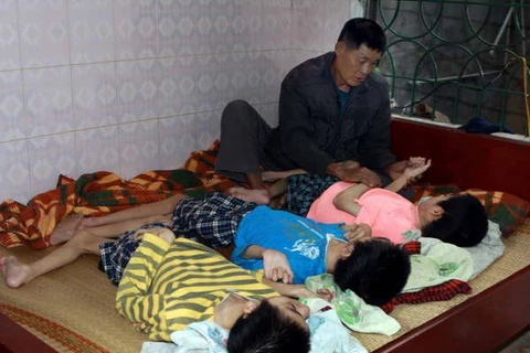 Une famille vietnamienne dispose de trois enfants, victimes de l'agent orange/dioxine. Source de photo/VNA