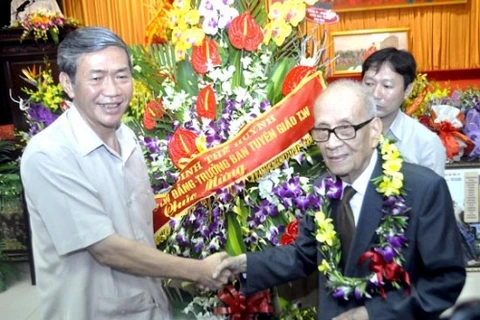 Dinh The Huynh, membre du Bureau politique, chef de la Commission de propagande et d’éducation du CC du PCV, félicite le professeur Vu Khieu à l'occasion de son centenaire. Photo : internet