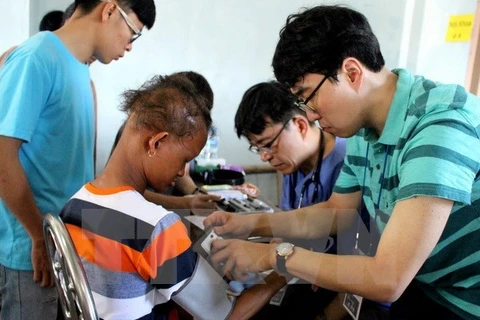 Des docteurs sud-coréens prodiguent des soins médicaux gratuits en faveur des personnes pauvres et ouvriers de la zone industrielle de Pho Noi A, province de Hung Yen. (Source : VNA). 