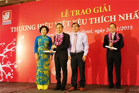 Mme Nguyên Thi Hông, à côté des représentants d'entreprises primées lors de la cérémonie de remise du prix «Marque préférée du Vietnam en 2014». 