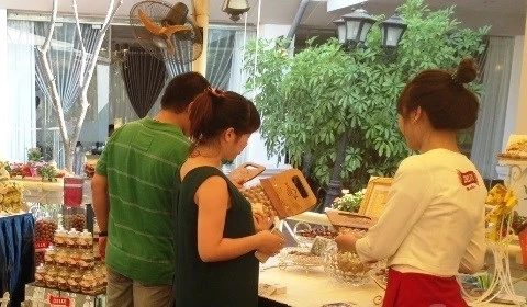 Les visiteurs contemplent et achètent les produits en macadamia lors du festival. (Source : VNA)