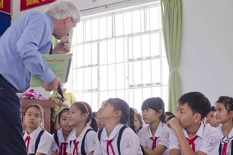 Le conférencier britannique Alec Williams lit des contes aux enfants de l’école primaire de Chanh My, de la province de Binh Duong. Photo: tuoitre.vn. 