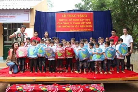 Des représentants de la Sarl Canon Vietnam offrent des cadeaux aux élèves de la province de Lao Cai. Photo: laodong.com.vn.