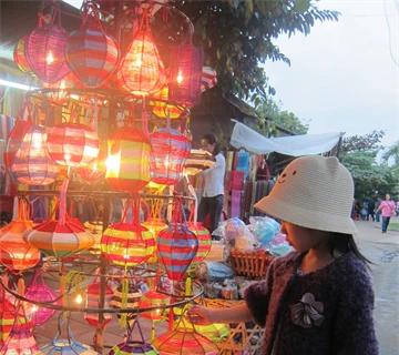 Une petite fille s'intéresse aux lanternes de couleur vive de Hôi An, province de Quang Nam (Centre). 