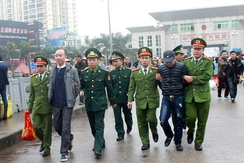 La police de la ville de Mong Cai a pris livraison par le département de la police de Dongxing, en Chine, de deux Vietnamiens recherchés. Photo: VNA
