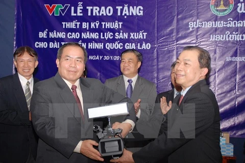 Tran Dung Trinh, vice-directeur général de la Télévision du Vietnam (droite), remet un cadeau au directeur de la Télévision nationale du Laos, Bounchau Phichit.