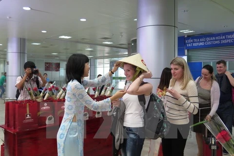 Des touristes russes reçoivent des cadeaux à l'aéroport de Cam Ranh, province de Khanh Hoa. (Photo: Tiên Minh/VNA)