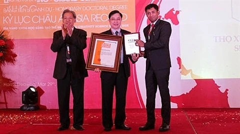 Phùng Tuân Giang (centre) reçoit le certificat de l’Organisation des records de l'Asie. Photo: VOV/CVN